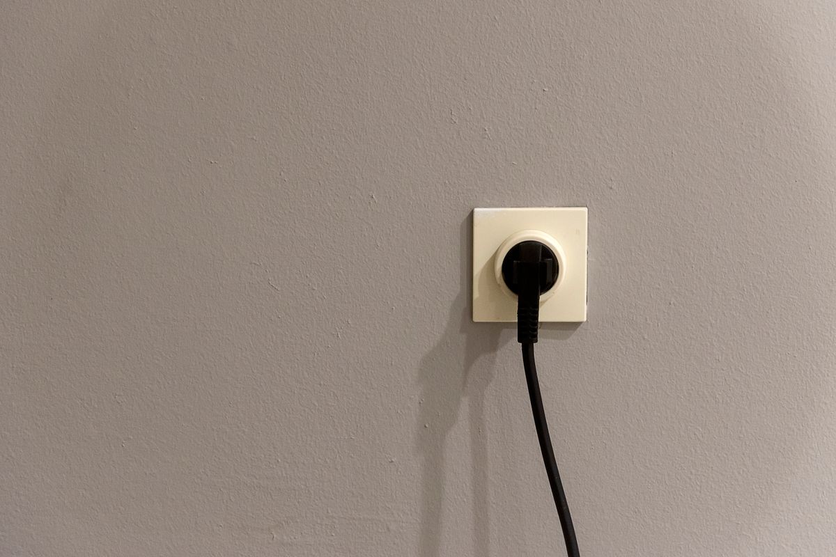 壁のコンセントに差さったプラグ。アダプタ電源だけだと停電で完全に止まる
