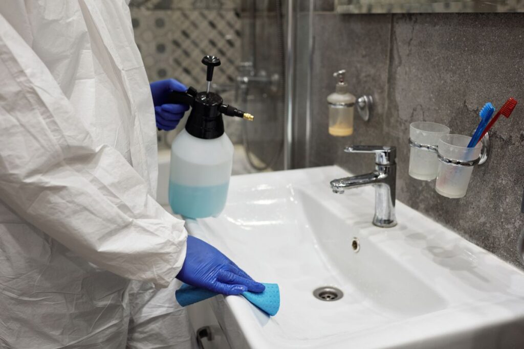 洗剤を吹きかけて洗う手元。角とふちに汚れが残る
