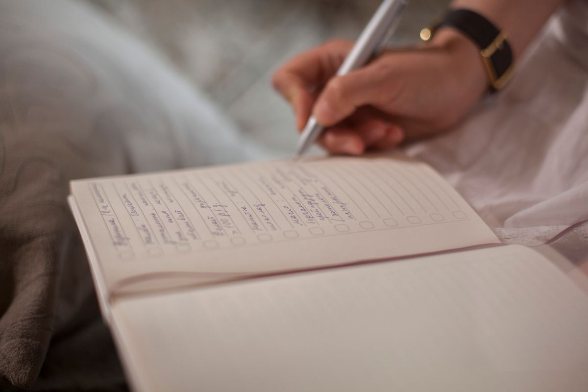 ノートに手書きで書きこんでいる手元。気づいたことを残す作業