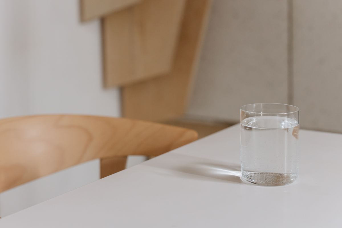 木のテーブルに置かれた水のグラス